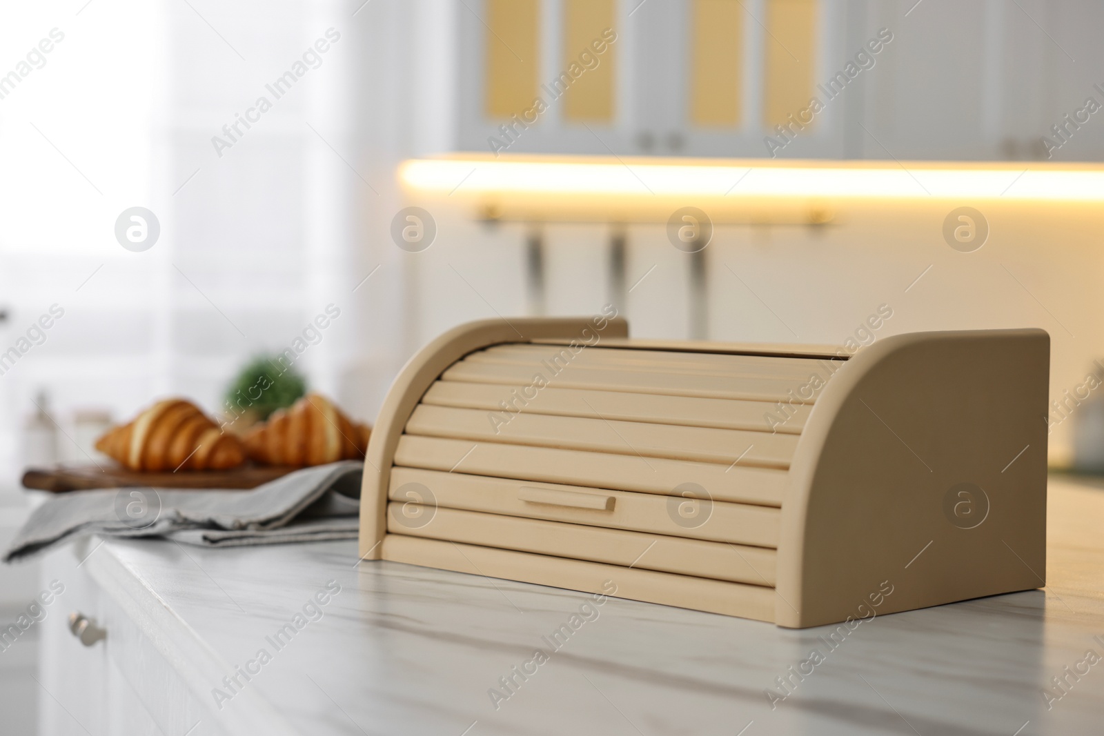 Photo of Wooden bread box on white marble countertop in kitchen