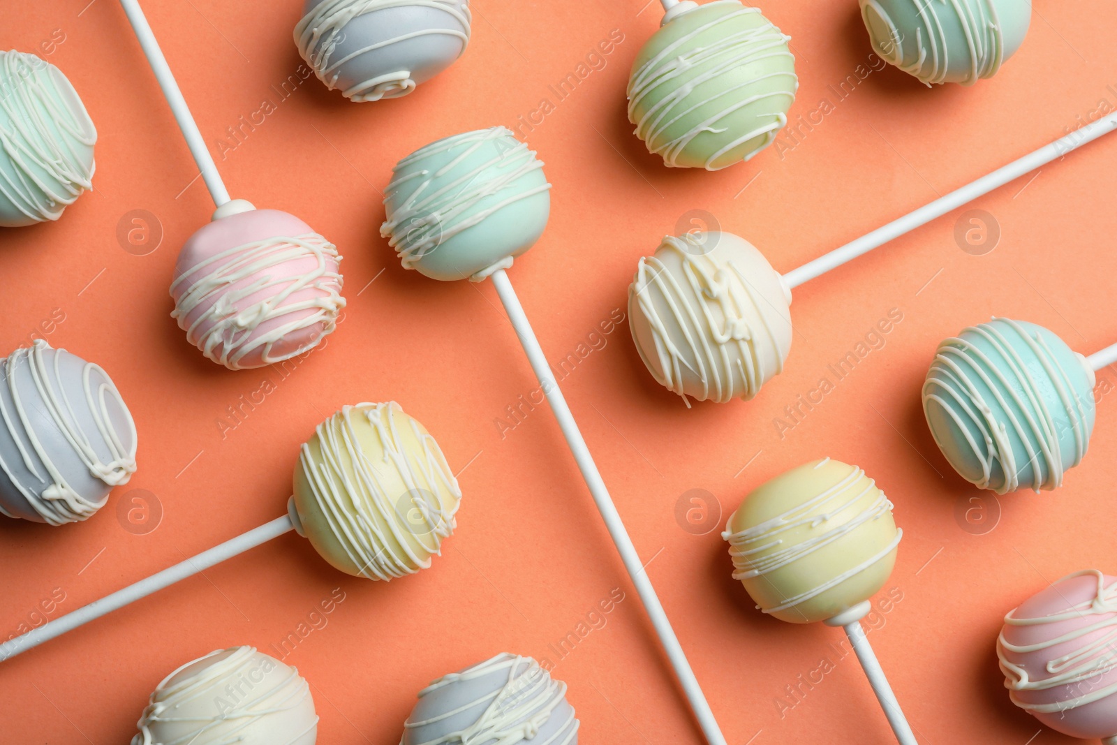 Photo of Sweet cake pops on orange background, flat lay