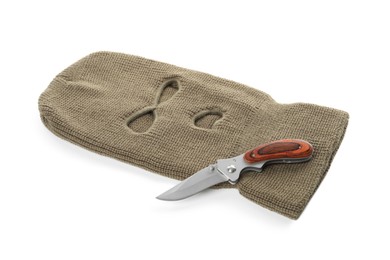 Photo of Beige knitted balaclava and knife on white background