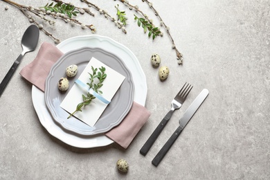 Photo of Festive Easter table setting with quail eggs on color background, flat lay