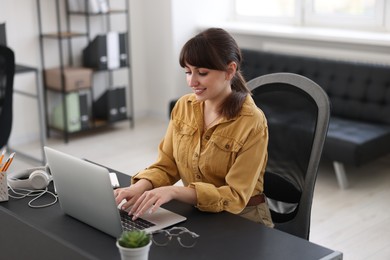 Photo of Woman watching webinar at table in office