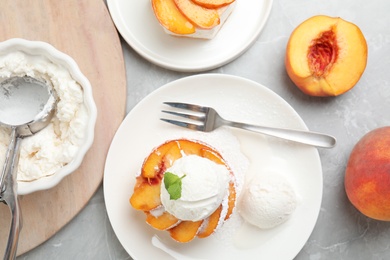 Photo of Delicious peach dessert with ice cream on light marble table, flat lay