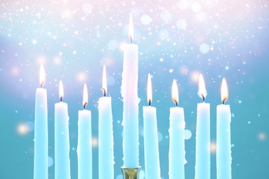 Image of Hanukkah celebration. Burning candles on light blue background with blurred lights, closeup