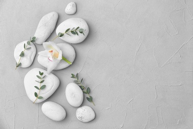 Photo of Spa stones and beautiful flower on light background