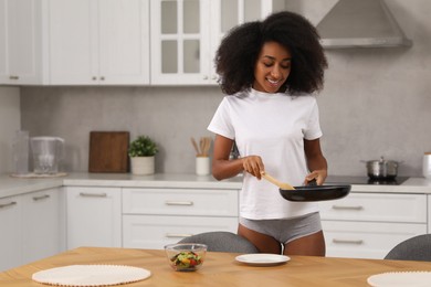 Photo of Beautiful woman in stylish underwear and t-shirt serving breakfast indoors, space for text