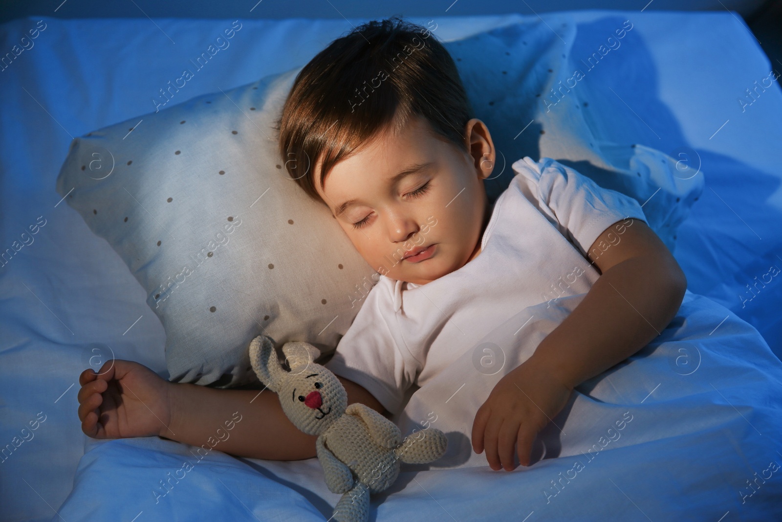 Photo of Cute little baby sleeping with toy at home. Bedtime