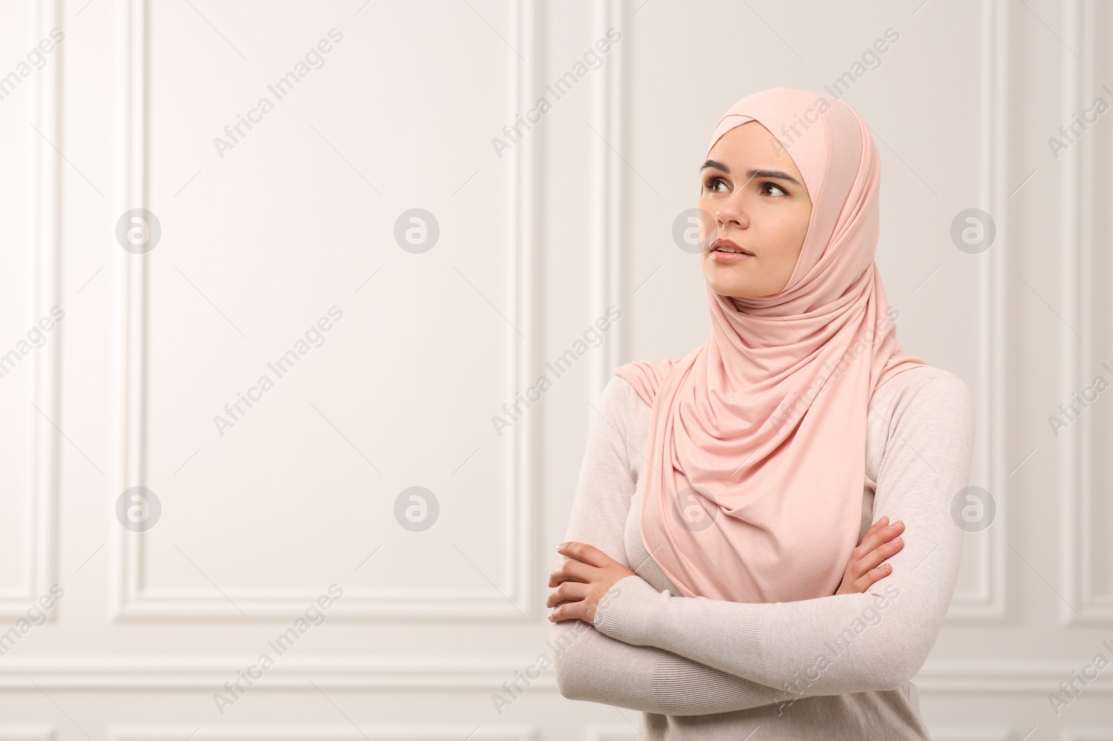 Photo of Muslim woman wearing hijab indoors, space for text