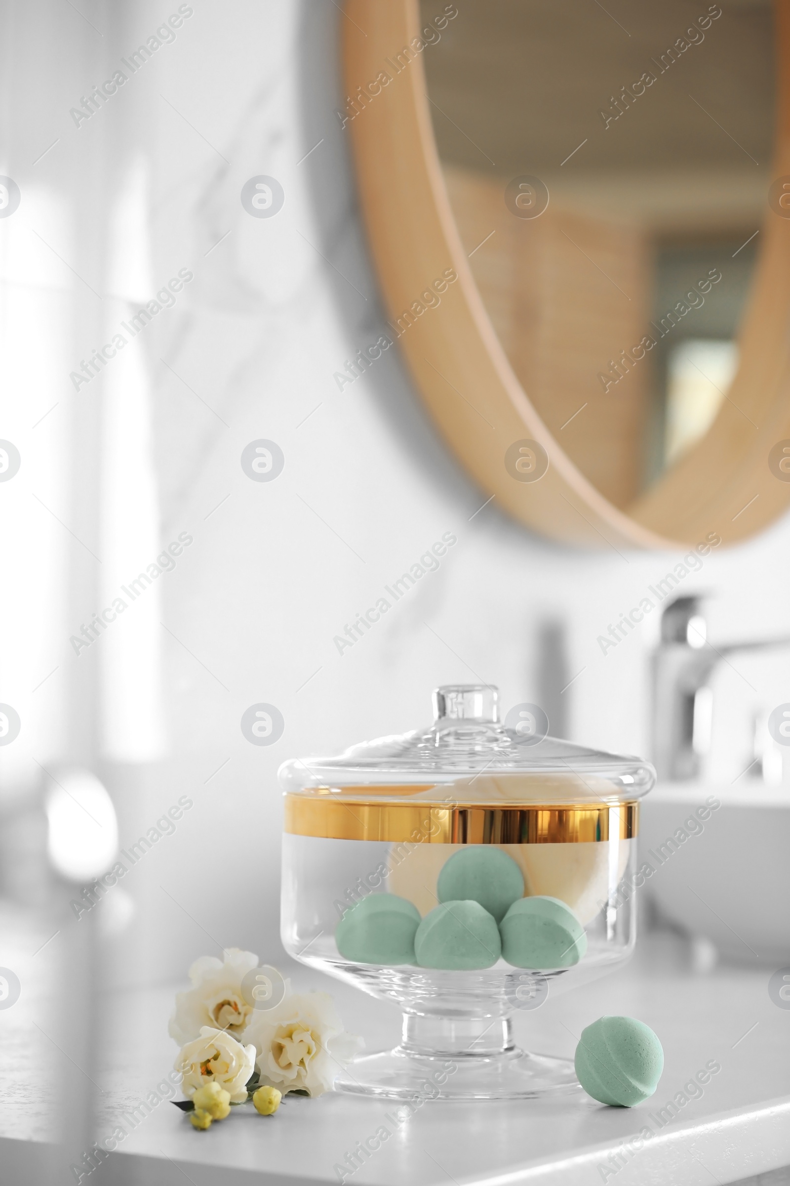 Photo of Jar with bath bombs and bath sponge on white countertop indoors
