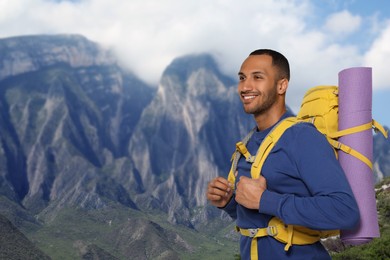 Image of Happy tourist with yellow backpack in mountains