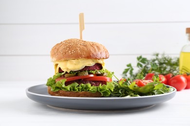 Delicious vegetarian burger served with salad on white wooden table