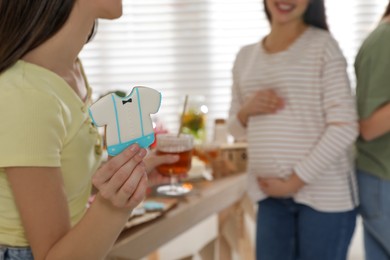 Woman with tasty cookie at baby shower party, closeup. Space for text