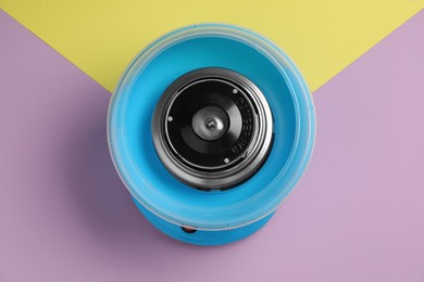 Portable candy cotton machine on color background, top view