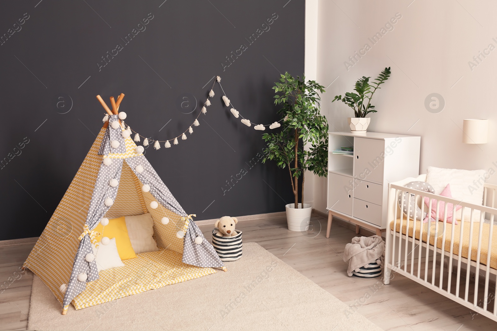 Photo of Cozy baby room interior with play tent and crib