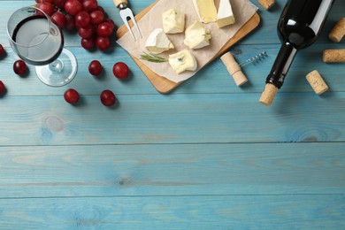 Flat lay composition with red wine and snacks on turquoise wooden table, space for text