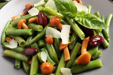 Delicious salad with green beans, mushrooms and cheese on plate, closeup