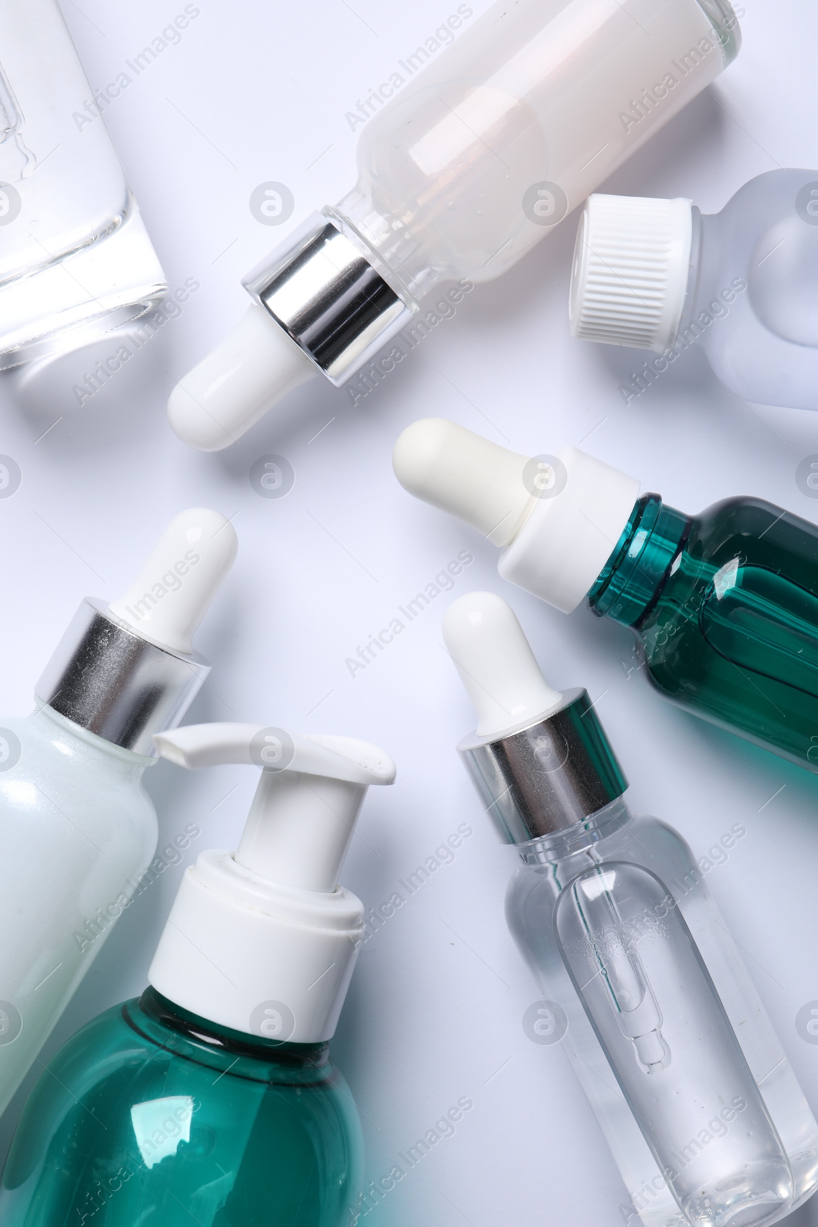 Photo of Face serums and other skin care products on white background, flat lay