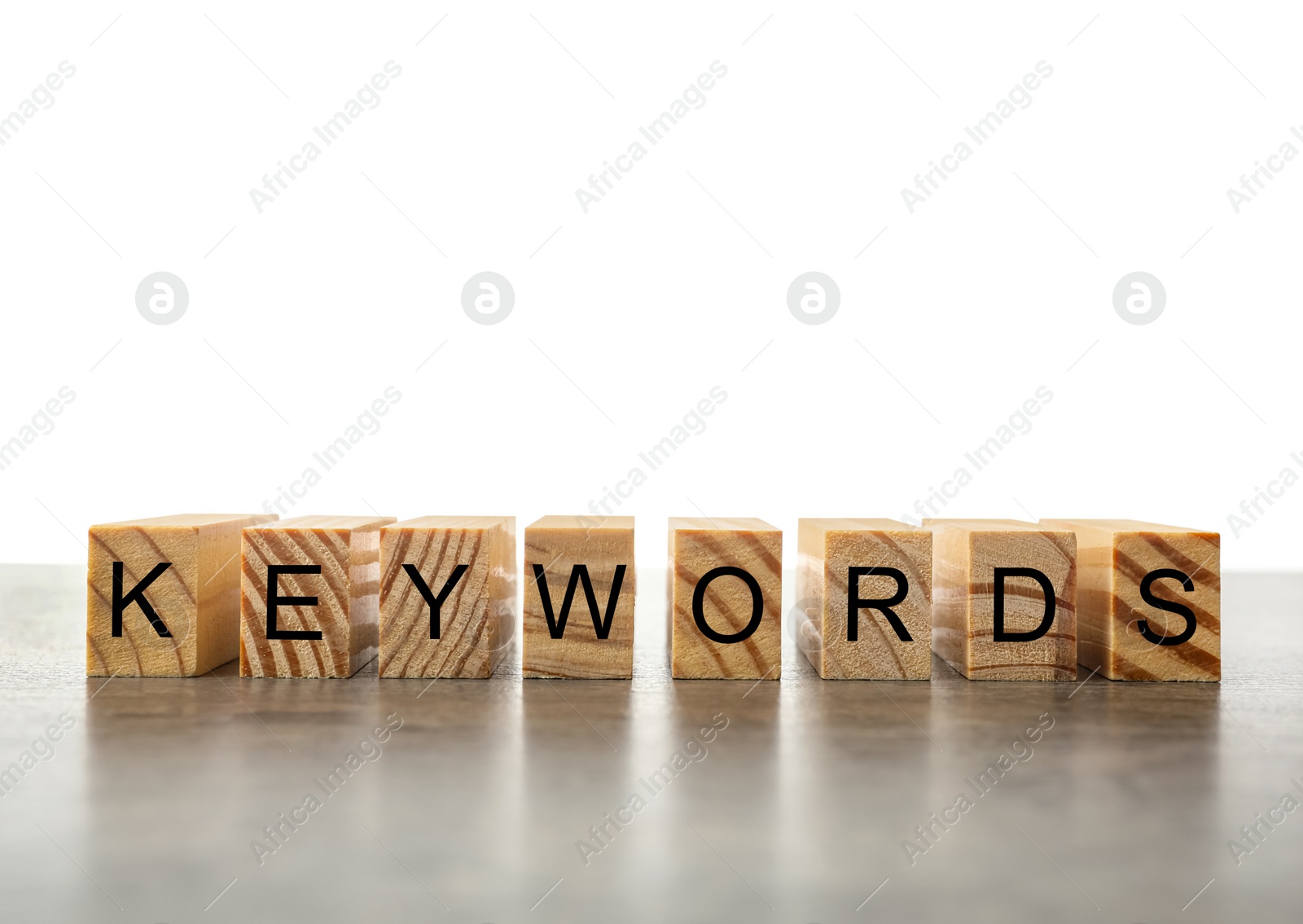 Photo of Word KEYWORDS made of wooden blocks on light grey table