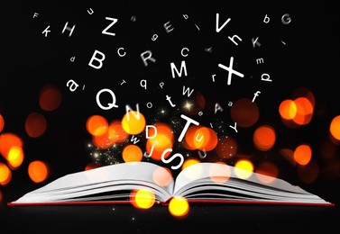 Image of Letters flying out from open book on black background, bokeh effect