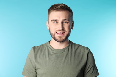 Young man with healthy teeth on color background