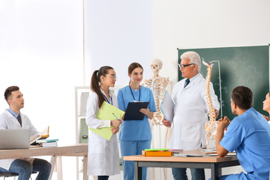 Photo of Medical students and professor studying human spine structure in classroom