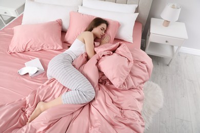 Photo of Young woman sleeping in comfortable bed with silky linens