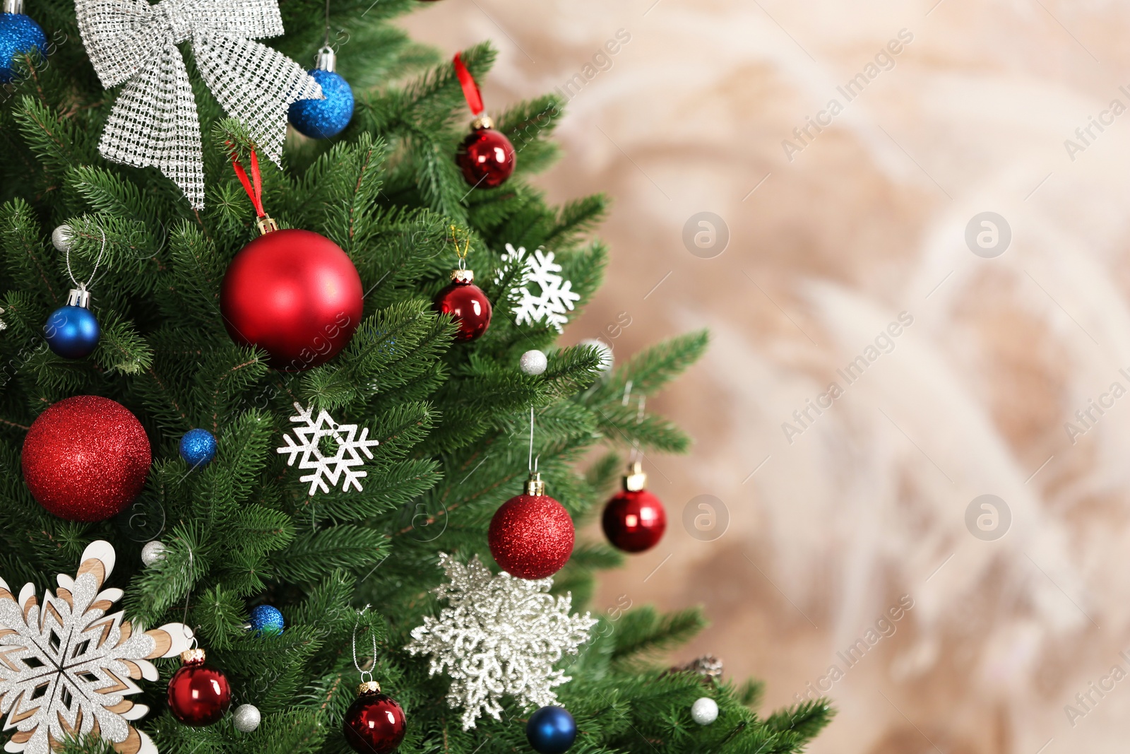 Photo of Beautiful Christmas tree with decor against brown background. Space for text