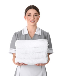 Photo of Young chambermaid holding stack of fresh towels on white background