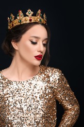 Photo of Beautiful young woman wearing luxurious crown on black background