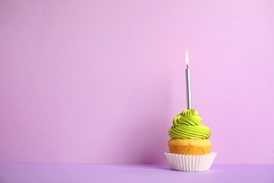 Birthday cupcake with candle on violet background, space for text