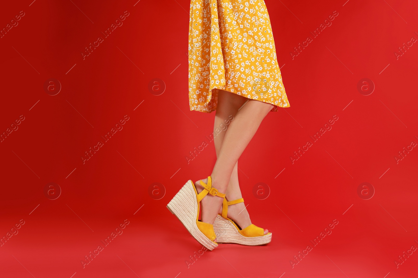 Photo of Woman in stylish shoes on red background