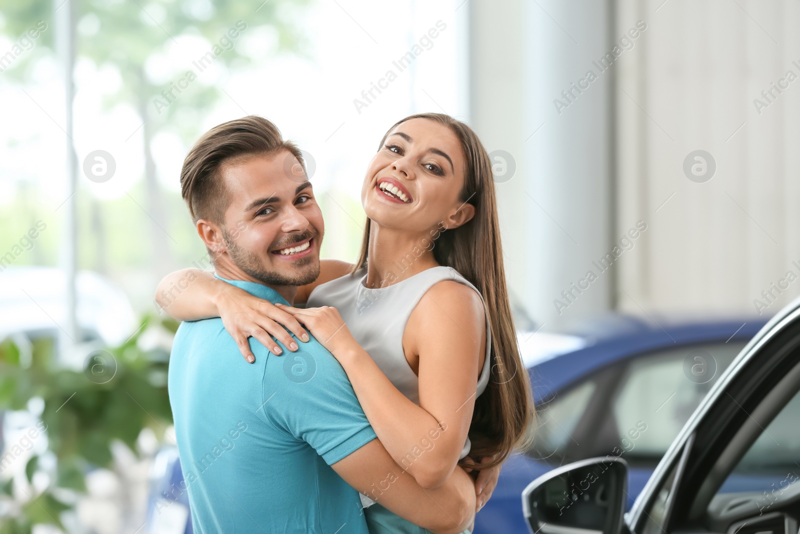 Photo of Happy couple buying new car in salon