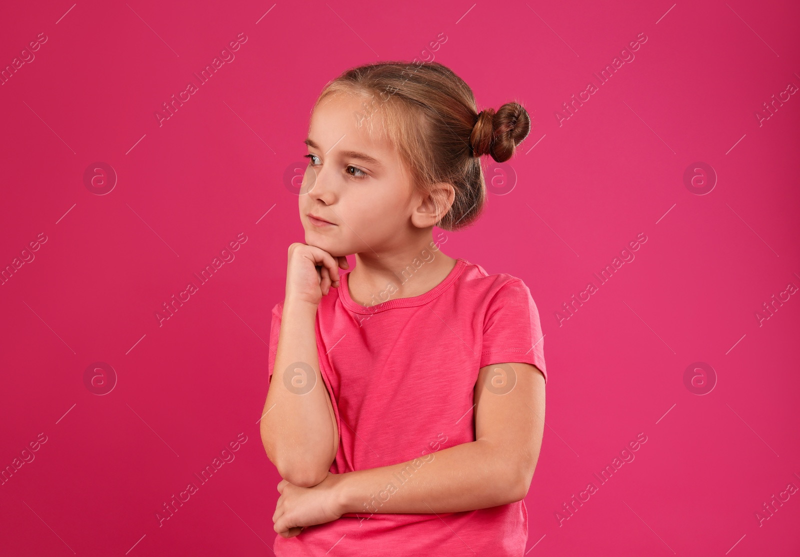 Photo of Cute little girl posing on pink background