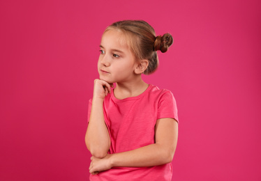 Cute little girl posing on pink background