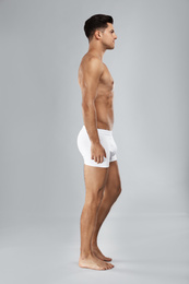 Photo of Handsome man in white underwear on light grey background