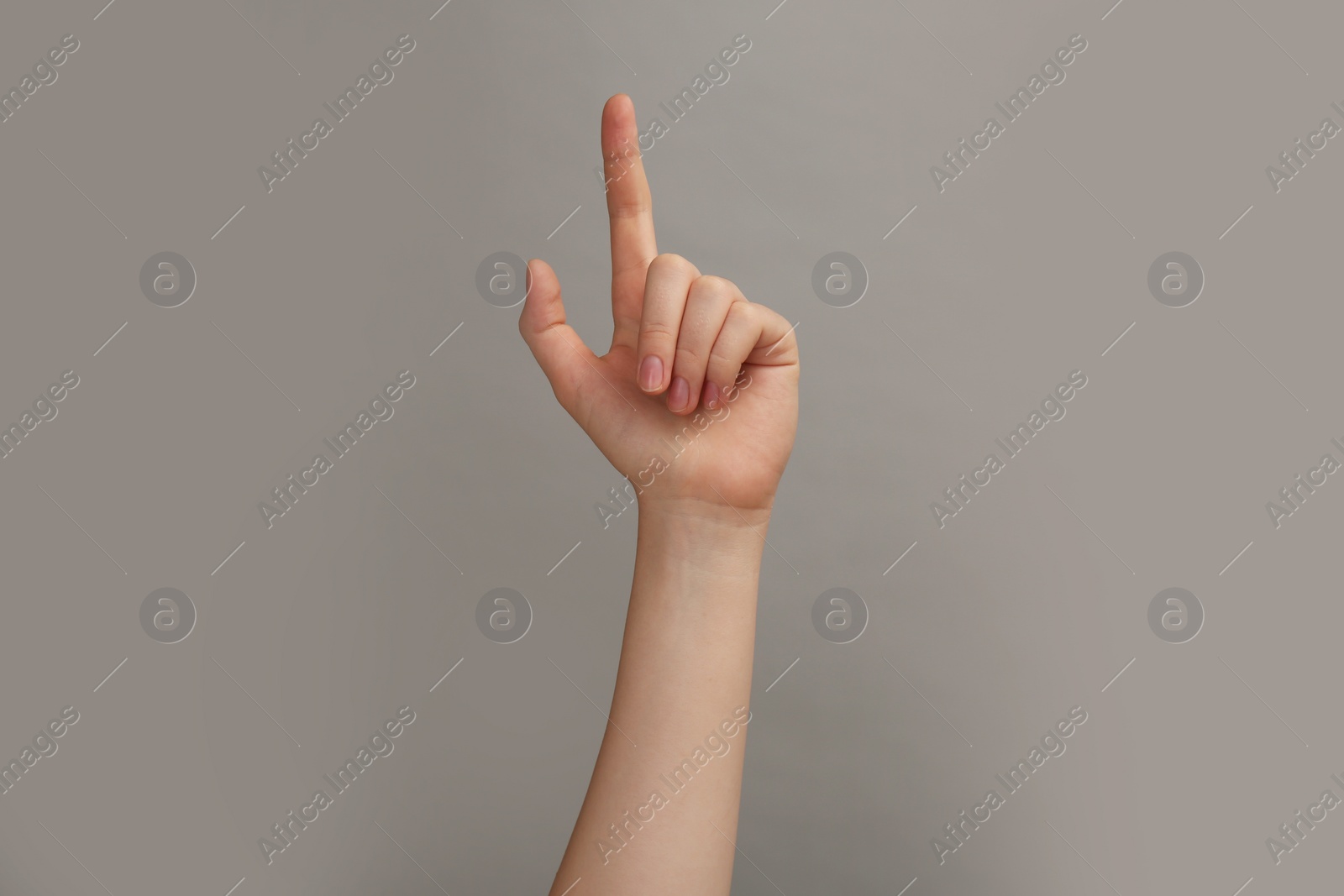 Photo of Woman showing index finger on grey background, closeup