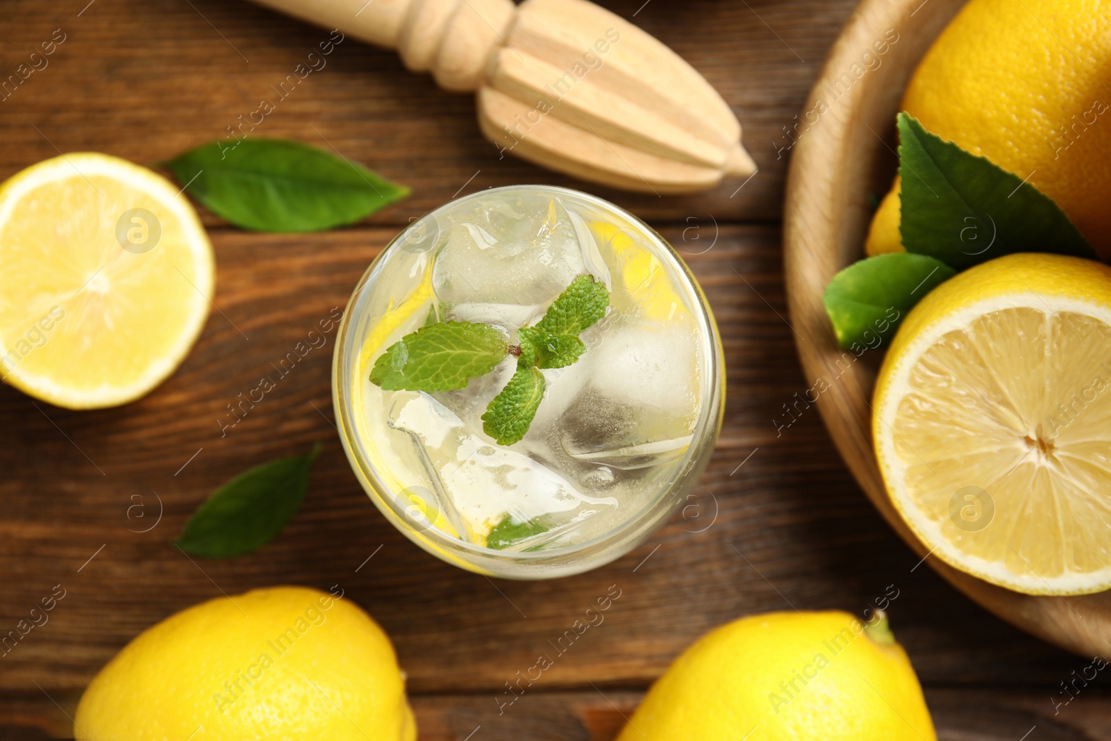 Photo of Cool freshly made lemonade reamer and fruits on wooden table, flat lay