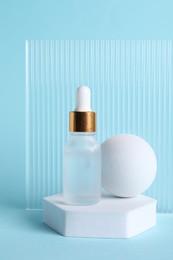 Photo of Stylish presentation of cosmetic serum on light blue background