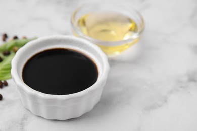 Photo of Bowl with balsamic vinegar on white table, closeup. Space for text