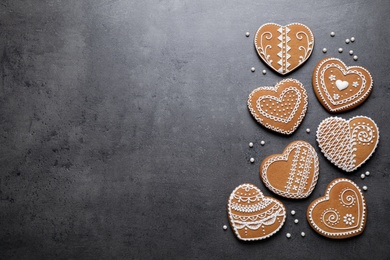 Tasty heart shaped gingerbread cookies on black table, flat lay. Space for text