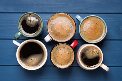 Photo of Many different cups of coffee on blue wooden table, flat lay