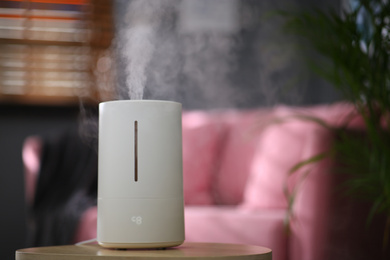 Modern air humidifier on table indoors. Space for text