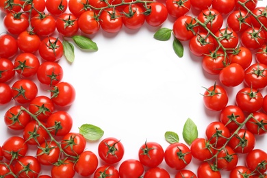 Flat lay composition with ripe cherry tomatoes and basil leaves on white background. Space for text