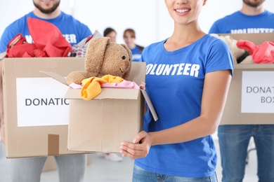 Photo of Young volunteers holding boxes with donations indoors