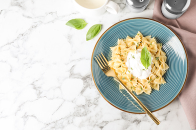 Flat lay composition with tasty pasta on white marble table, space for text