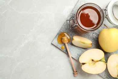 Flat lay composition with jar of honey, apples and dipper on marble background