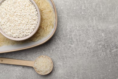 Different sorts of rice on grey table, flat lay. Space for text