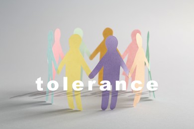 Tolerance, support and cooperation concept. Colorful paper human figures making circle on white background