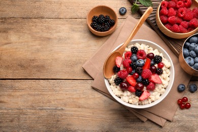 Photo of Flat lay composition with tasty oatmeal porridge and ingredients served on wooden table. Space for text