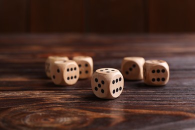 Photo of Many game dices on wooden table, closeup
