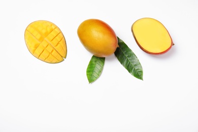 Photo of Tropical cut and whole mango with green leaves isolated on white, flat lay. Space for text